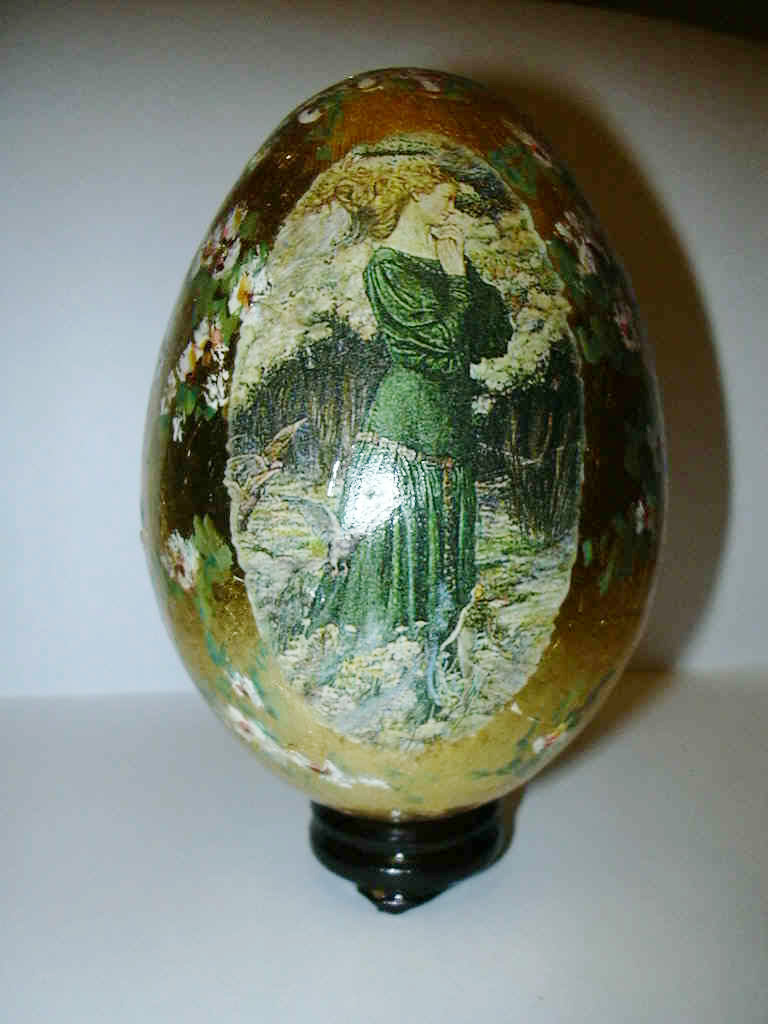 uovo dorato in foglia con motivi dipinti a tempera e figura applicata a decoupage